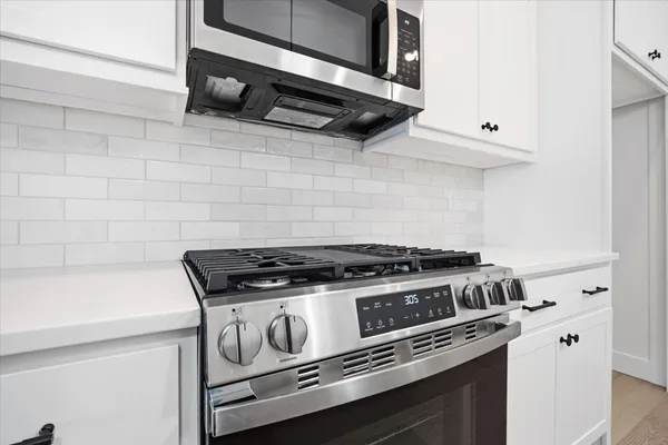 a stove top oven sitting inside of a kitchen