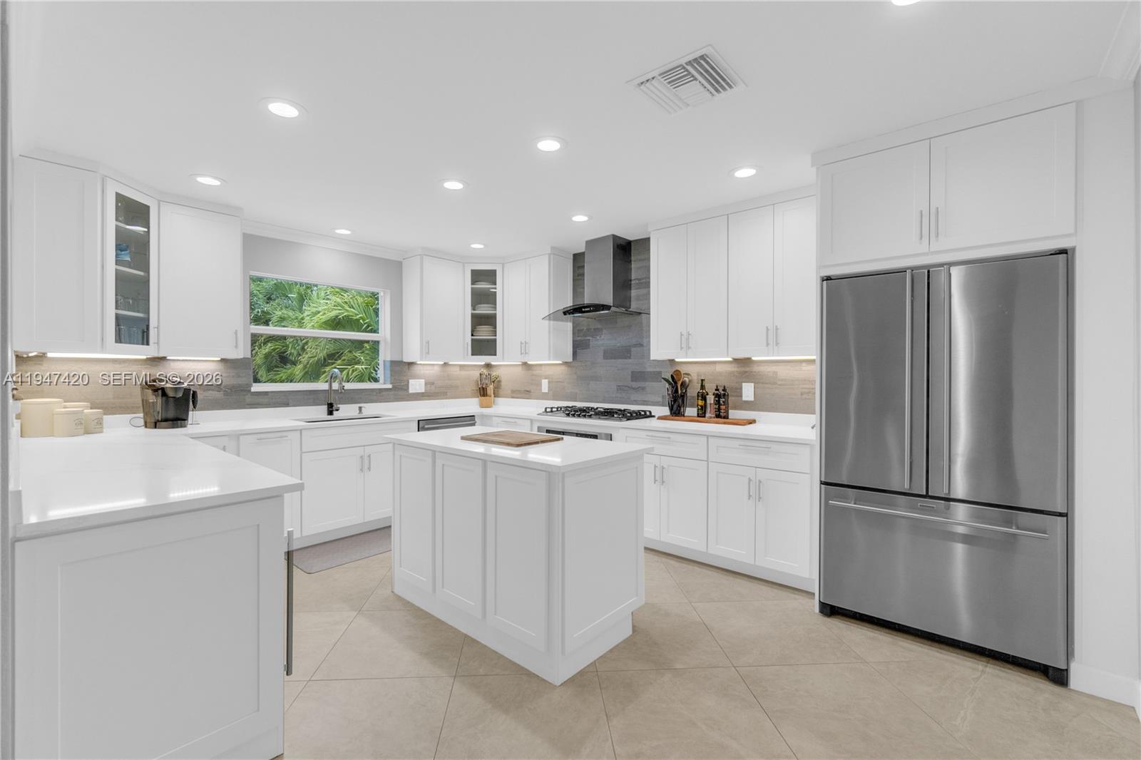 1405 Southwest 4th Terrace Pompano Beach, FL 33060 - Photo 13 of 44 a kitchen with white cabinets and stainless steel appliances