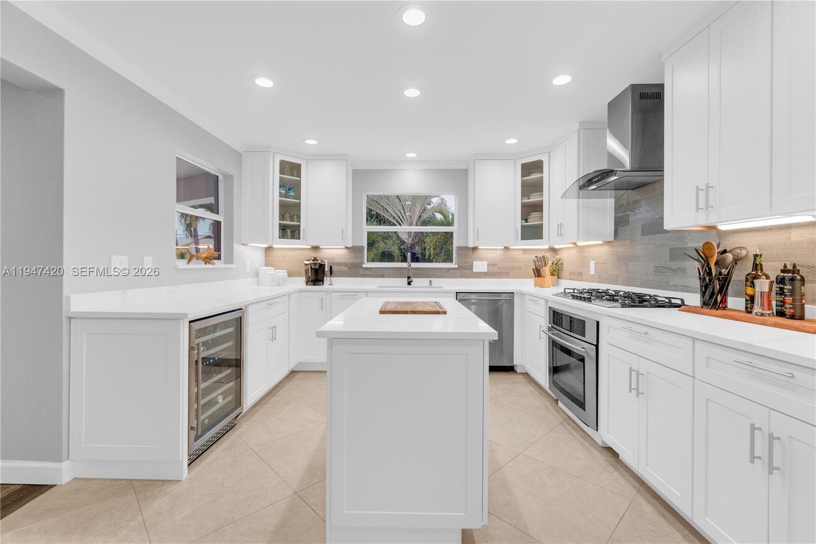1405 Southwest 4th Terrace Pompano Beach, FL 33060 - Photo 17 of 44 a kitchen with white cabinets stove and sink