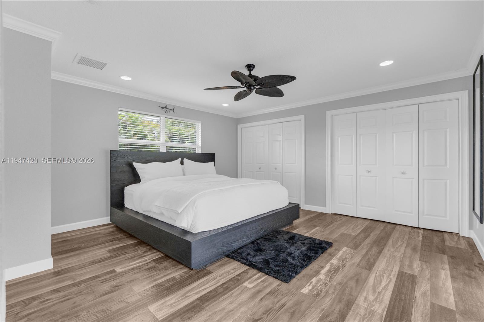 1405 Southwest 4th Terrace Pompano Beach, FL 33060 - Photo 25 of 44 a spacious bedroom with a bed and a chandelier