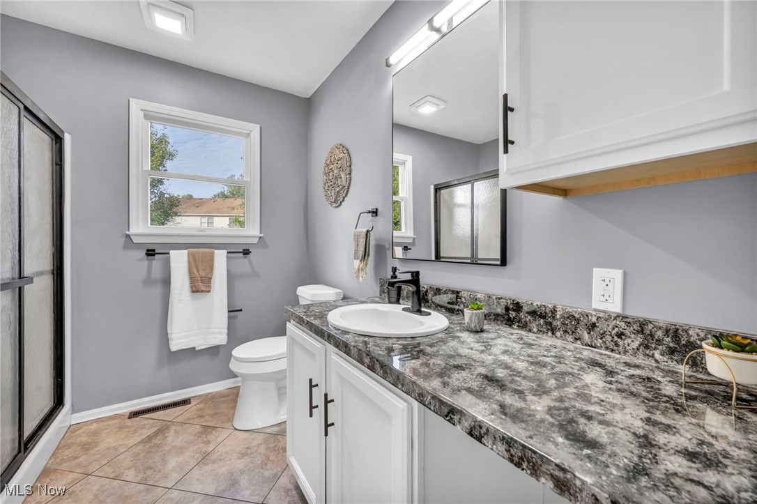 246 Rowland Road Vermilion, OH 44089 - Photo 25 of 39 Bathroom featuring walk in shower, vanity, tile patterned flooring, and toilet