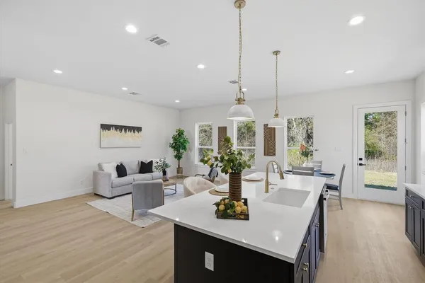 a view of a dining room and livingroom with furniture wooden floor a chandelier