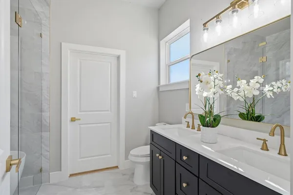 a bathroom with a granite countertop sink a toilet and mirror