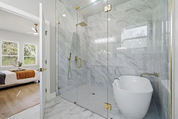 a bathroom with a tub shower and window