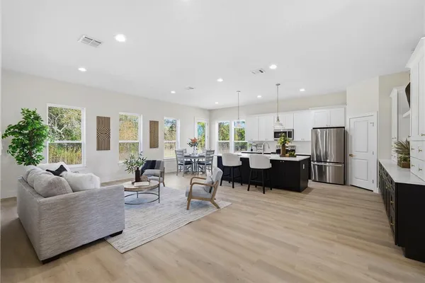 a living room with furniture kitchen and a large window