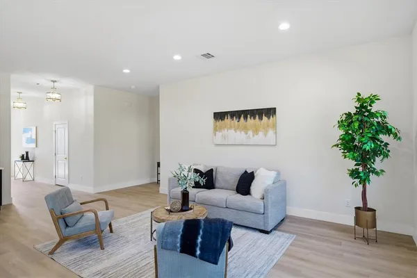 a living room with furniture potted plant and a wooden floor