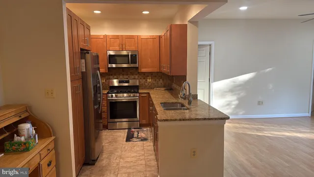a kitchen with stainless steel appliances granite countertop a stove and a refrigerator