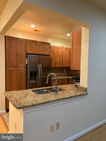 a kitchen with kitchen island granite countertop stainless steel appliances and sink