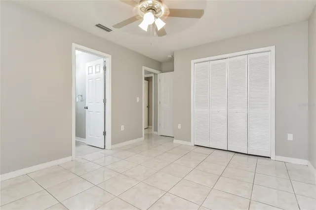 an empty room with fan and windows