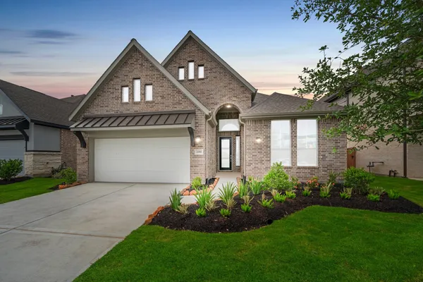 a front view of a house with a garden and plants