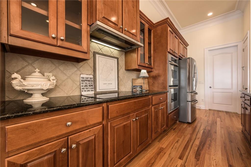 9510 Lisa Circle Gainesville, GA 30506 - Photo 32 of 80 a kitchen with stainless steel appliances granite countertop a refrigerator a sink dishwasher and wooden cabinets with wooden floor