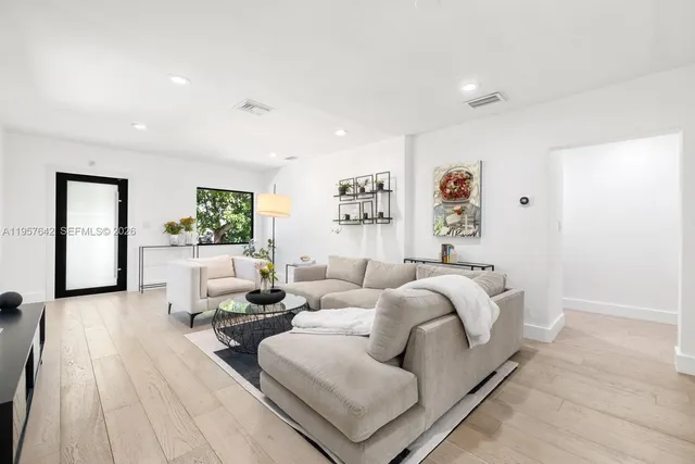 a living room with furniture and wooden floor