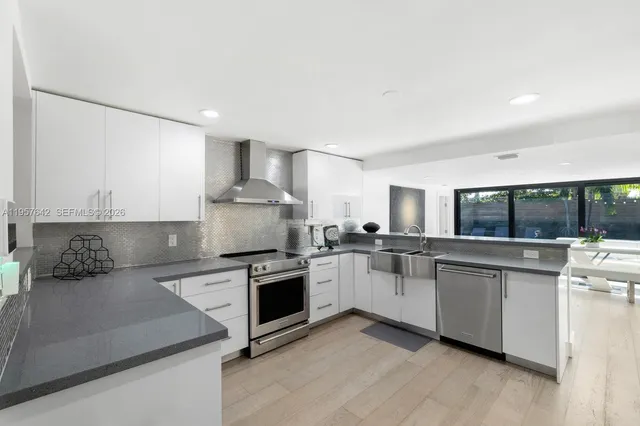 a kitchen with white cabinets a sink and appliances