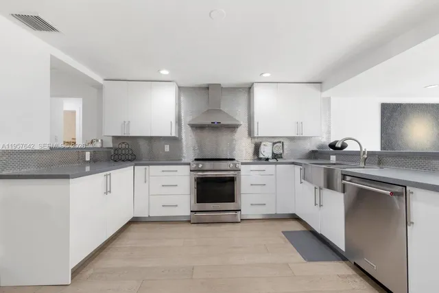 a kitchen with granite countertop white cabinets and white appliances