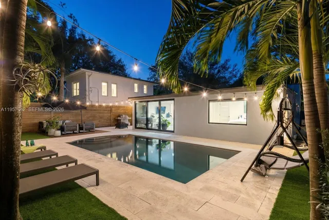 a view of a swimming pool with a patio and a yard