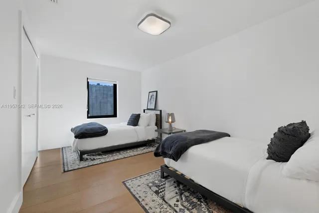 a bedroom with two beds and painting on the wall