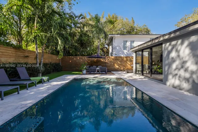 an aerial view of residential houses with outdoor space and trees