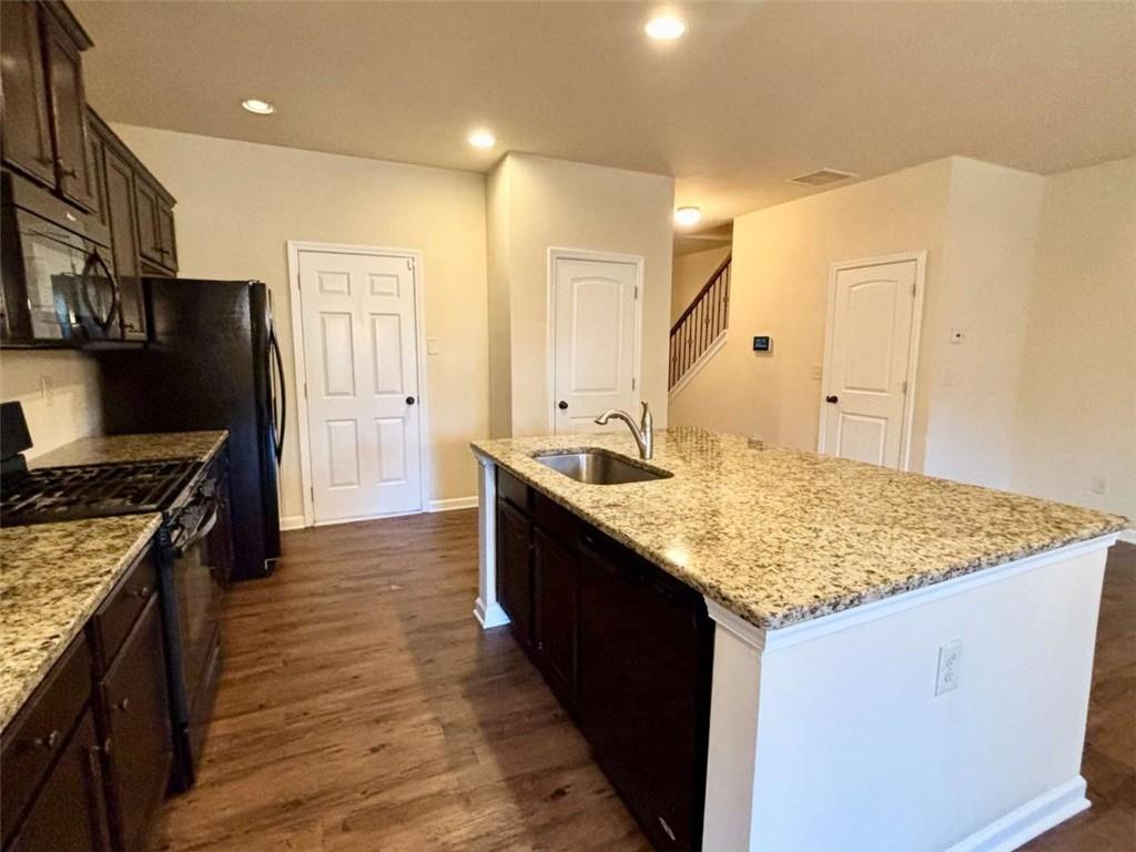 2723 Morgan Glen Road Northeast Buford, GA 30519 - Photo 7 of 25 a kitchen with stainless steel appliances granite countertop a sink stove and refrigerator