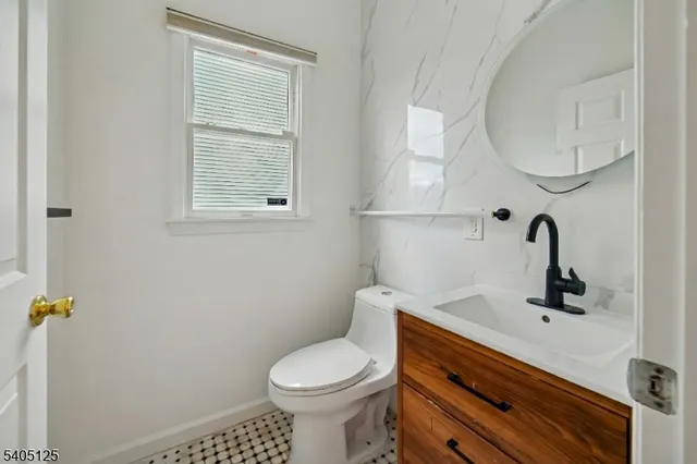 a bathroom with a sink mirror vanity and toilet