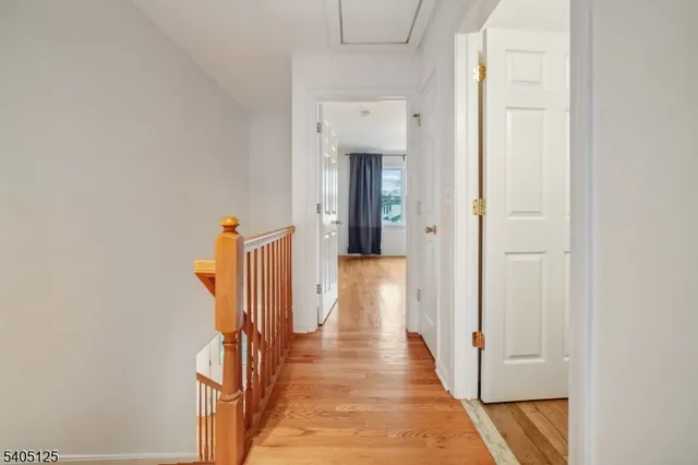 a view of a hallway with wooden floor and entryway