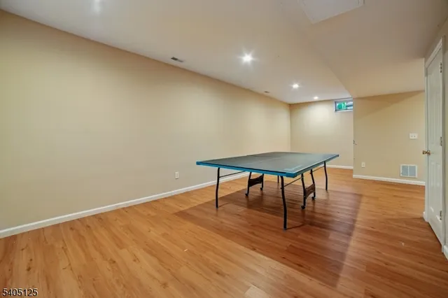 a view of a room with wooden floor and a table