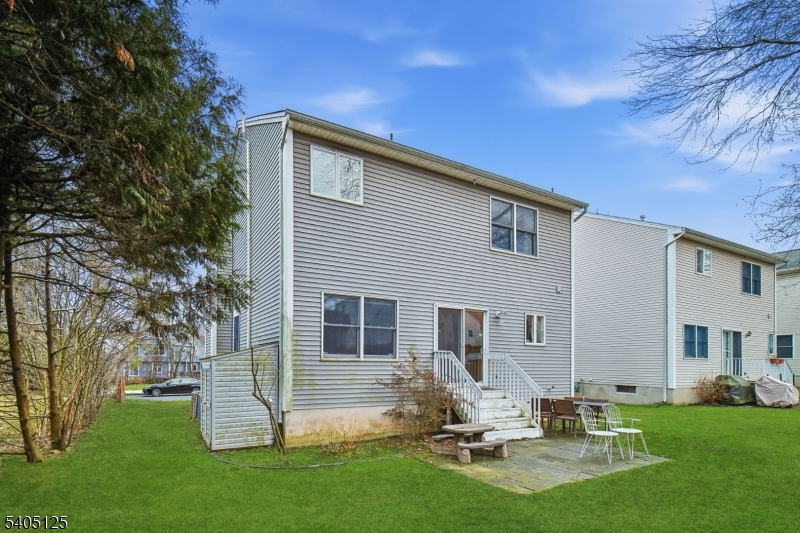 17 Grove Street Summit, NJ 07901 - Photo 41 of 42 a backyard of a house with table and chairs and potted plants and large tree