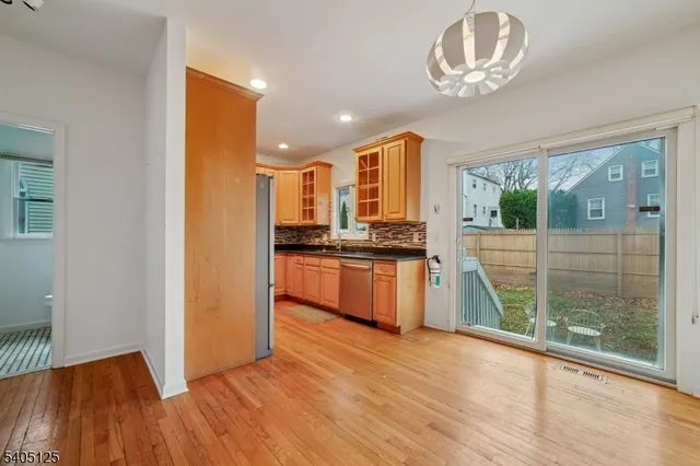 a kitchen with kitchen island stainless steel appliances a large window and wooden floor