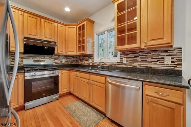 a kitchen with stainless steel appliances granite countertop a stove a sink and a microwave