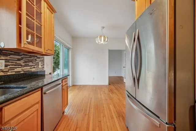 a view of a kitchen with a sink and refrigerator