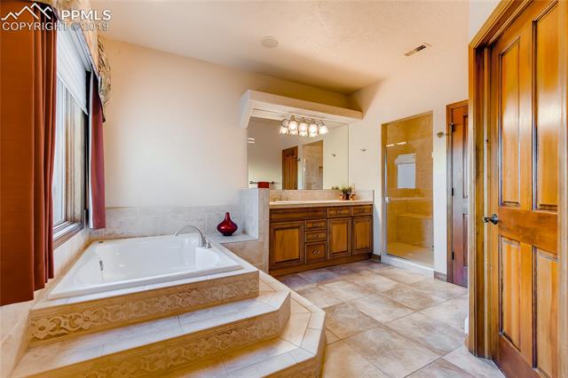 6155 Wilson Road Colorado Springs, CO 80919 - Photo 17 of 35 Master bathroom includes his / hers separate walk-in closets and sinks. Spa-like stand-up shower