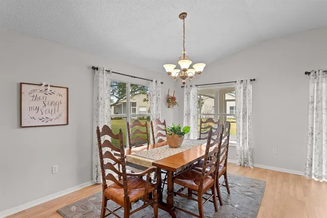 a view of a dining room with furniture a chandelier and wooden floor