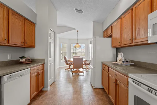 a kitchen with a stove top oven a sink dishwasher and white cabinets with wooden floor