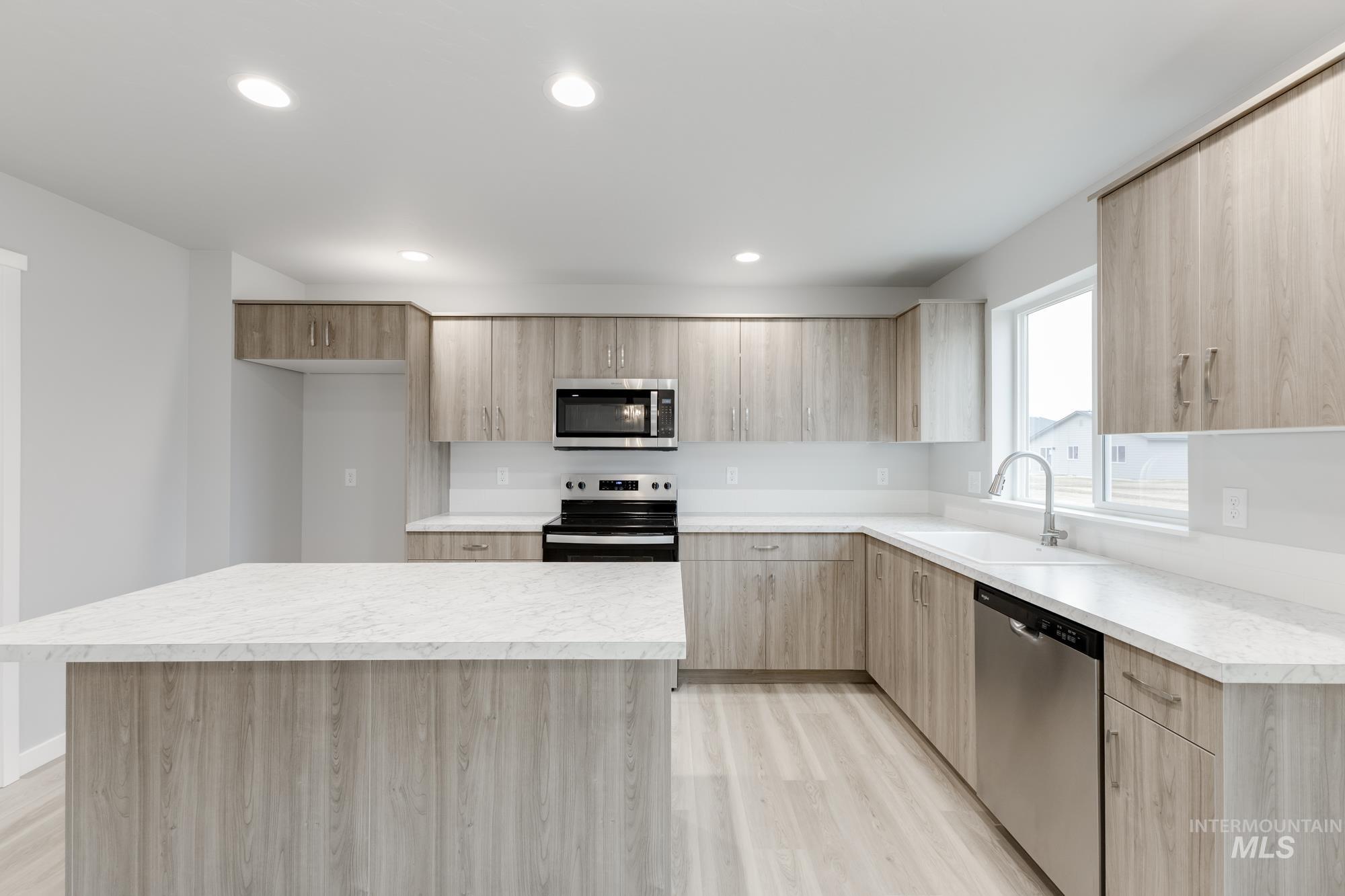 1591 Covington Street Middleton, ID 83644 - Photo 4 of 23 Kitchen with stainless steel appliances, light countertops, light brown cabinetry, modern cabinets, and recessed lighting