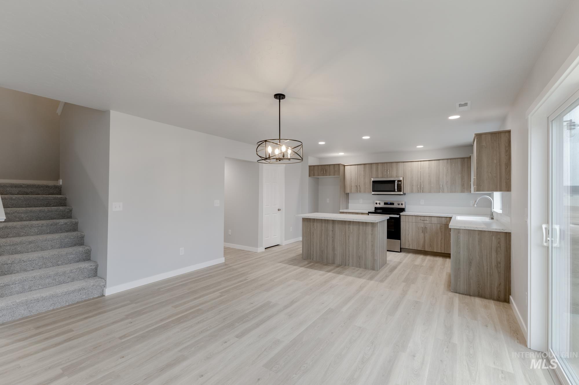1591 Covington Street Middleton, ID 83644 - Photo 23 of 23 Kitchen featuring open floor plan, a center island, modern cabinets, appliances with stainless steel finishes, and light countertops