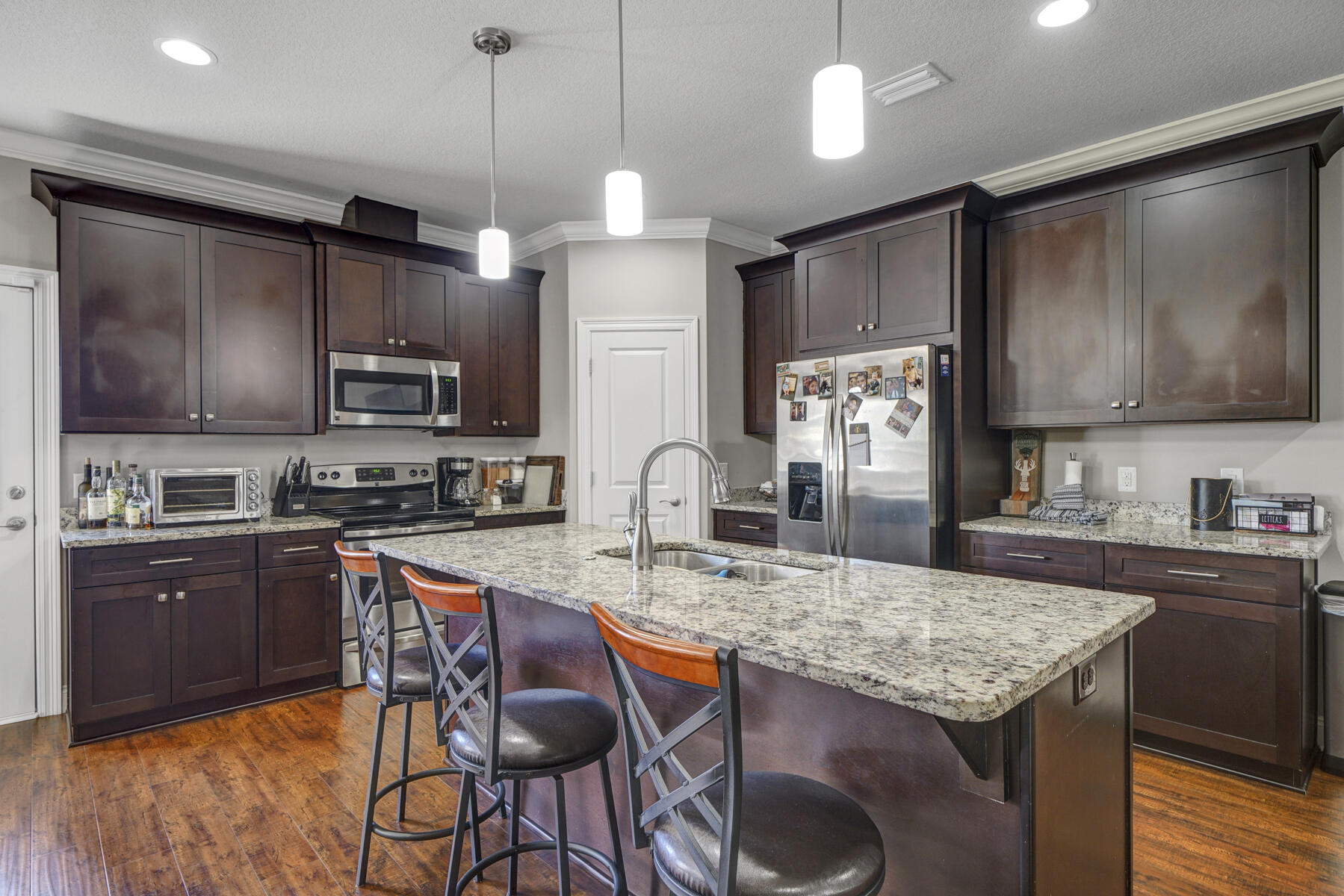 2136 Nina Street Navarre, FL 32566 - Photo 5 of 28 a kitchen with granite countertop kitchen island stainless steel appliances a stove sink microwave and cabinets