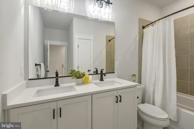 a bathroom with a sink toilet vanity and shower