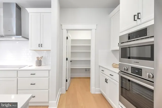 a kitchen with white cabinets and stainless steel appliances
