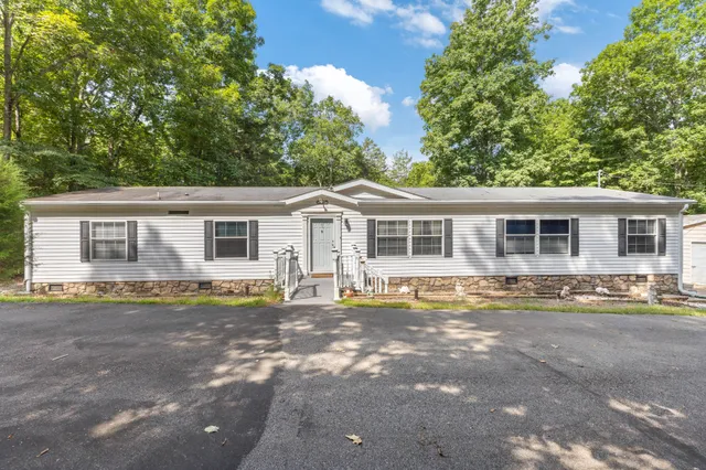 a view of a house with a yard and large tree