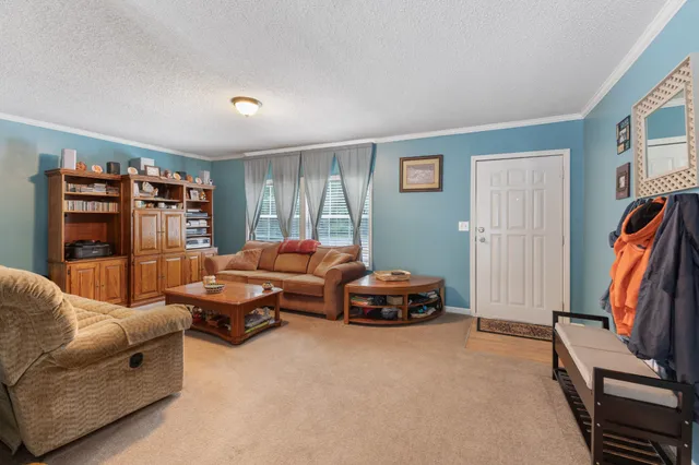 a kitchen with stainless steel appliances granite countertop a refrigerator a sink dishwasher a stove and white countertops with wooden floor