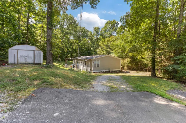 a kitchen with stainless steel appliances a refrigerator a sink dishwasher a stove and white cabinets with wooden floor