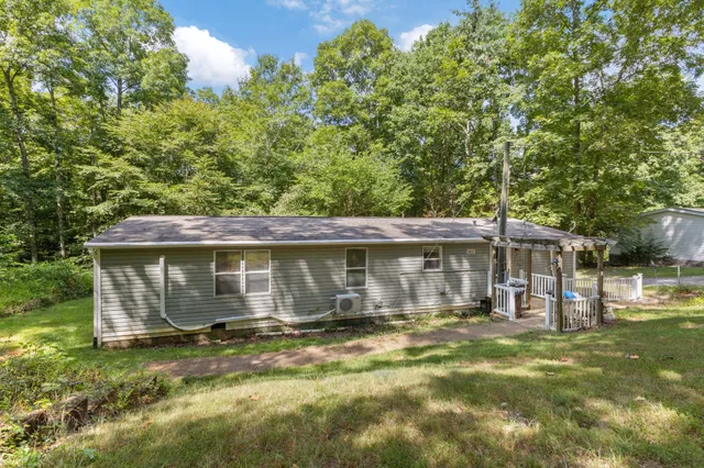 a view of a dining room and livingroom with furniture wooden floor a chandelier