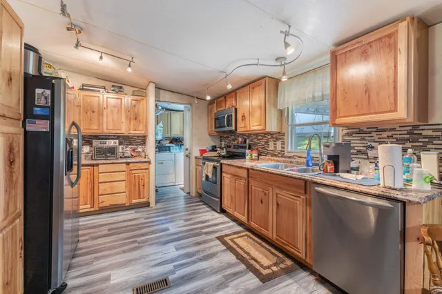 a bedroom with a bed a dresser and potted plant