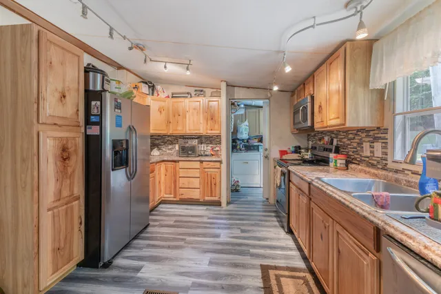 a bathroom with a granite countertop double vanity sink a mirror and a shower