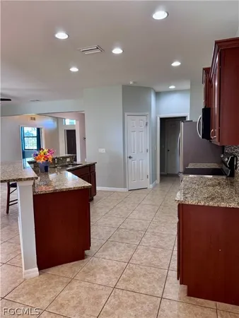 a kitchen with granite countertop a refrigerator and a sink