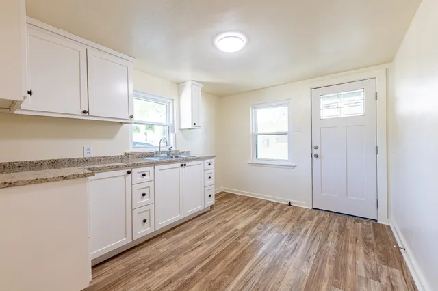 a kitchen with granite countertop white cabinets and white appliances