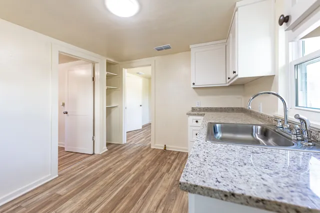 a kitchen with granite countertop a sink and a refrigerator