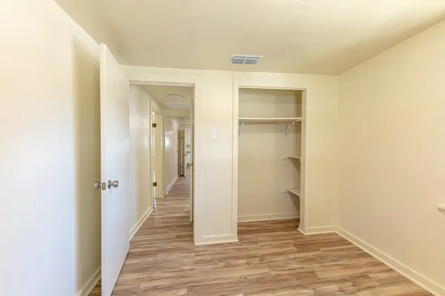 a view of a hallway with wooden floor