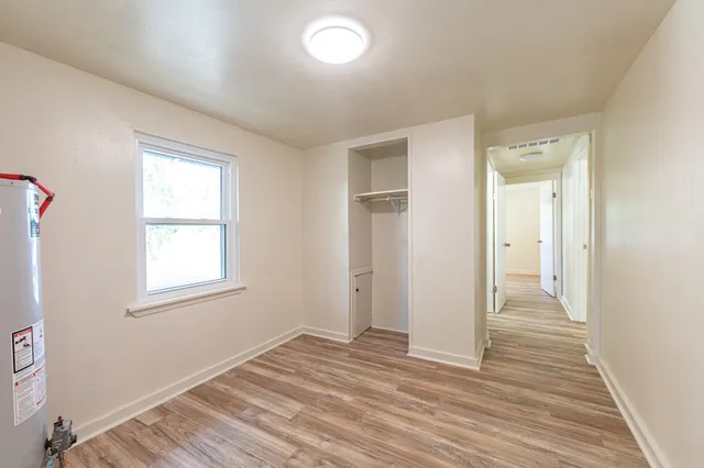 an empty room with wooden floor and a window