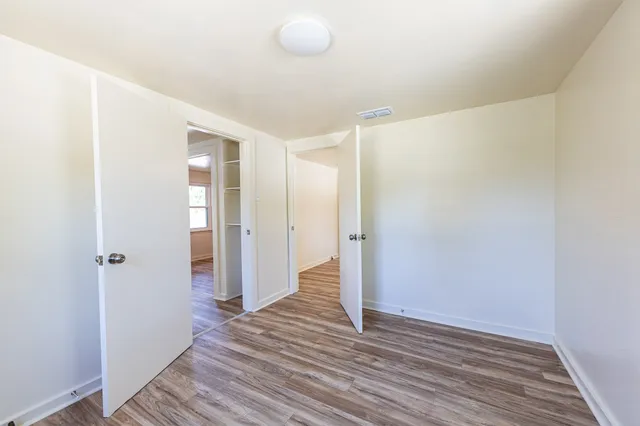 a view of an empty room with wooden floor