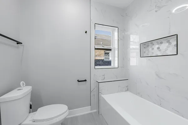 a bathroom with a toilet and a tub